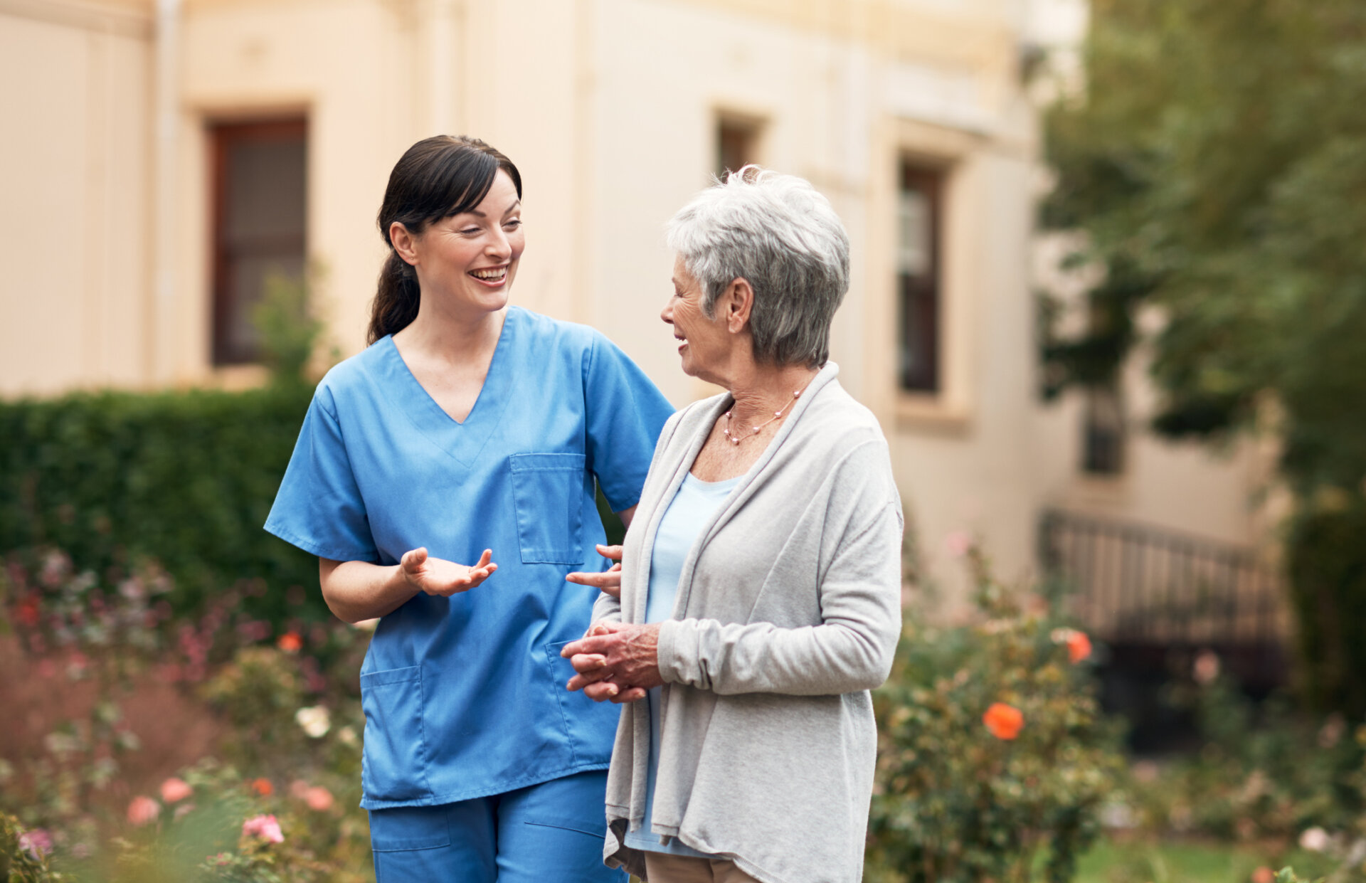 Caregiver assisting a senior living resident outdoors at Traditions of Beavercreek senior living community in Beavercreek, OH
