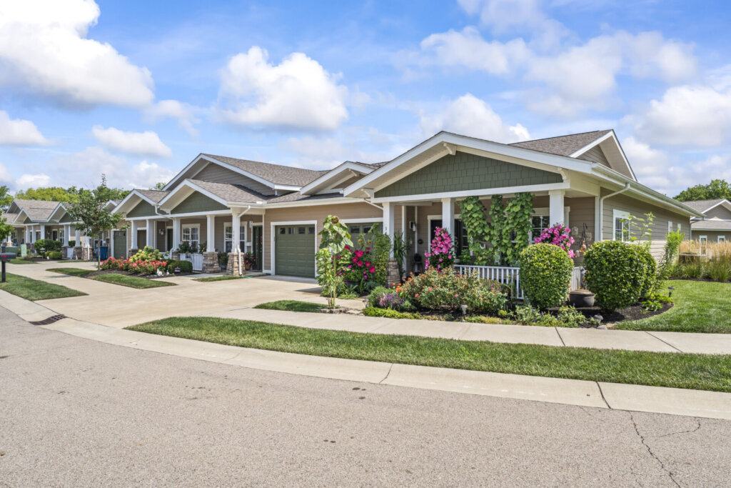 Traditions of Beavercreek Garden Homes featuring lush greenery, lined in a row on a well-maintained street