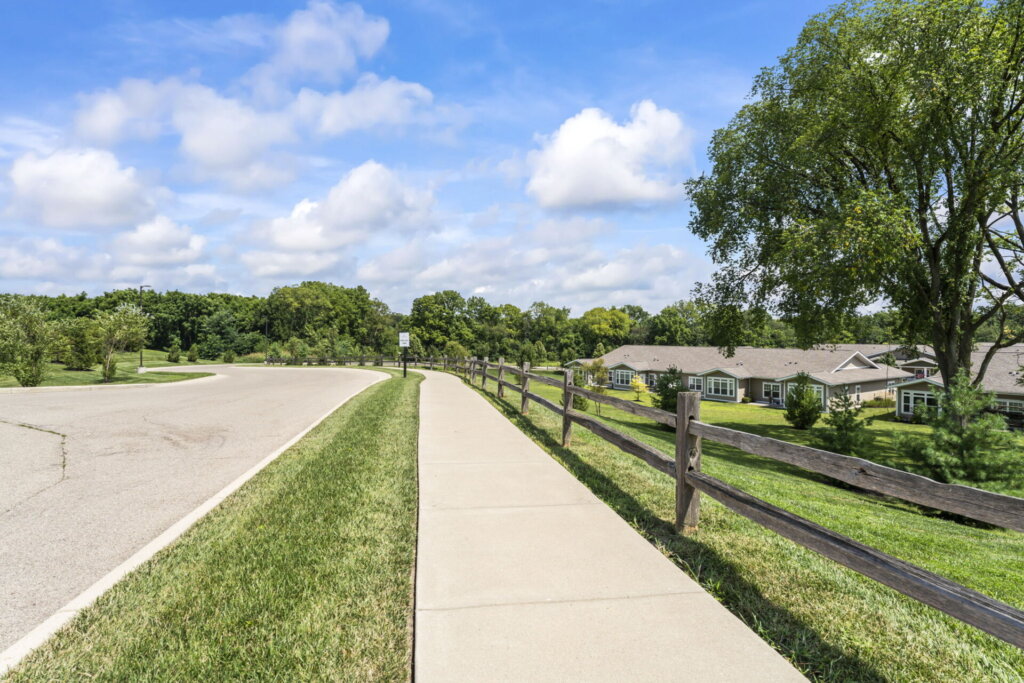 Traditions of Beavercreek's walking path a fence on the right and the garden homes in the background.
